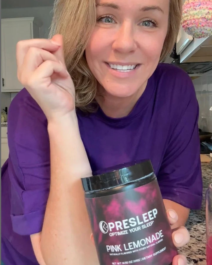 Smiling PreSleep customer holding her jar of Pink Lemonade in her kitchen